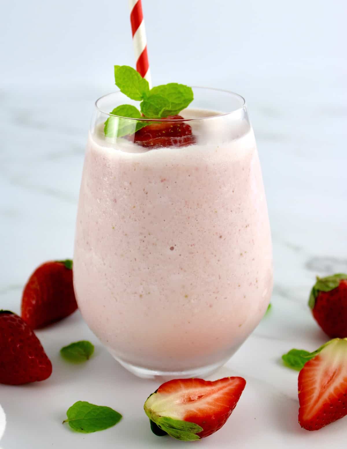 side view of Keto Strawberry Cheesecake Smoothie with mint and strawberry garnish