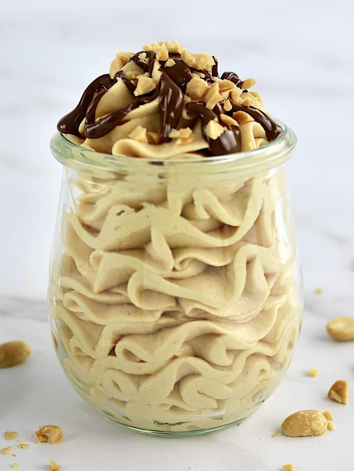 side view of Peanut Butter Mousse with melted chocolate and chopped peanuts on top