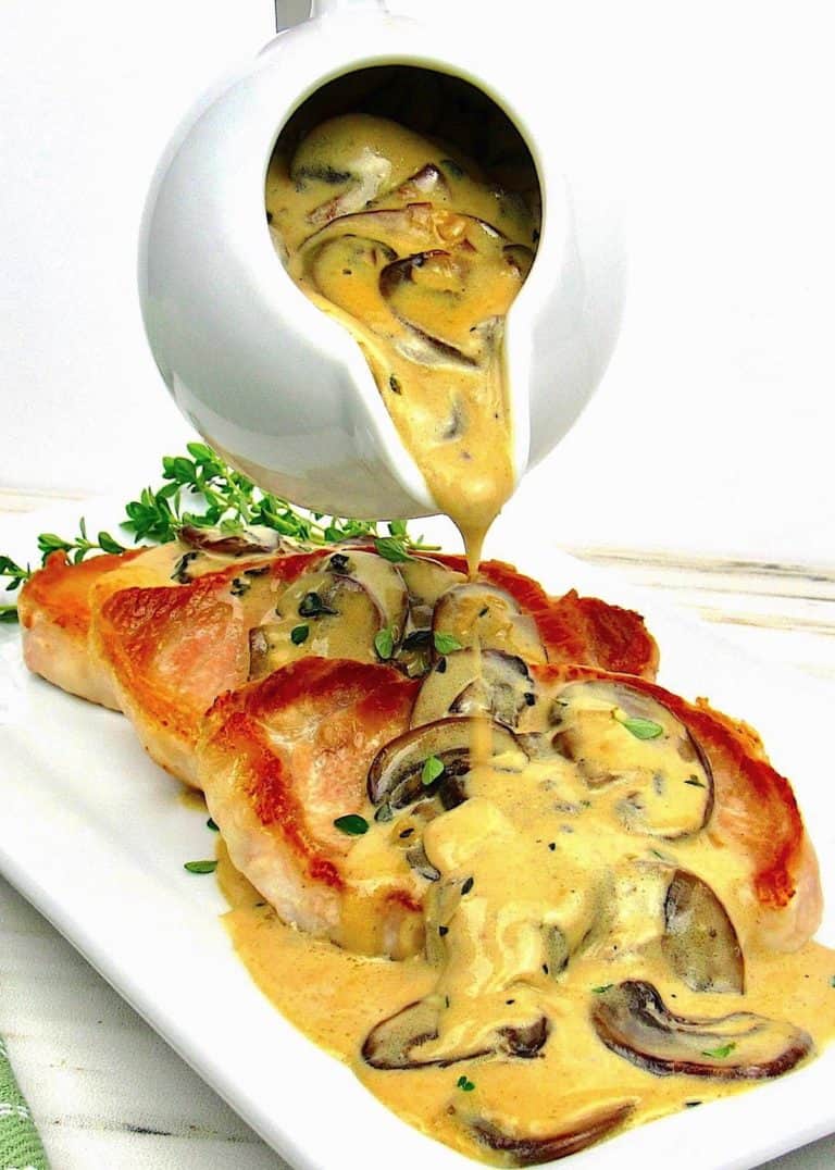 Creamy Mushroom Gravy being poured over pork chops