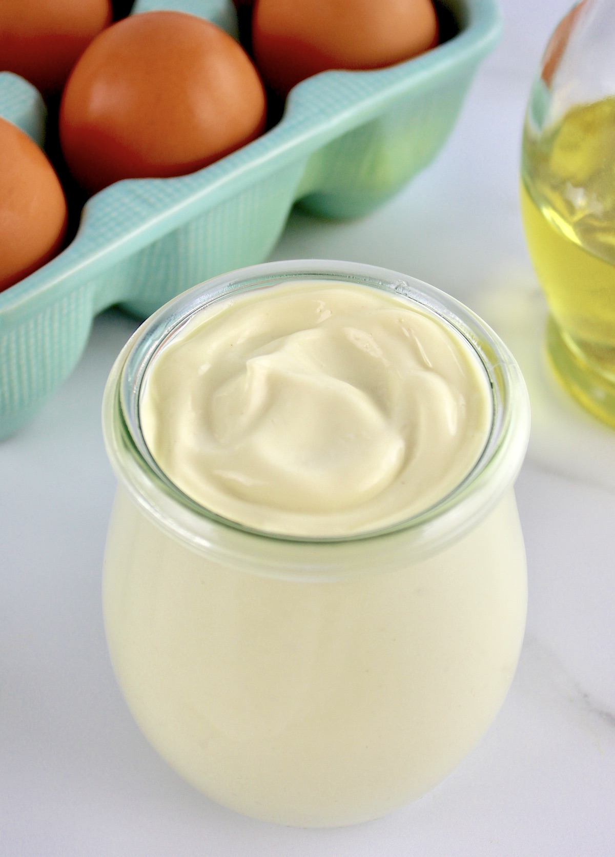 Easy Homemade Keto Mayonnaise in open glass jar with eggs and oil in background
