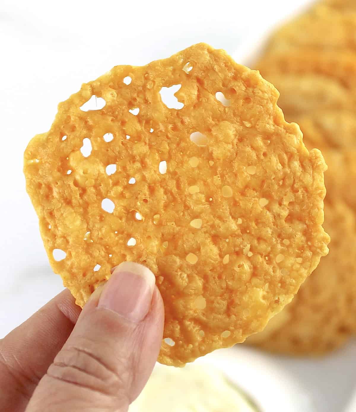 holding up Keto Baked Cheese Crisp Cracker