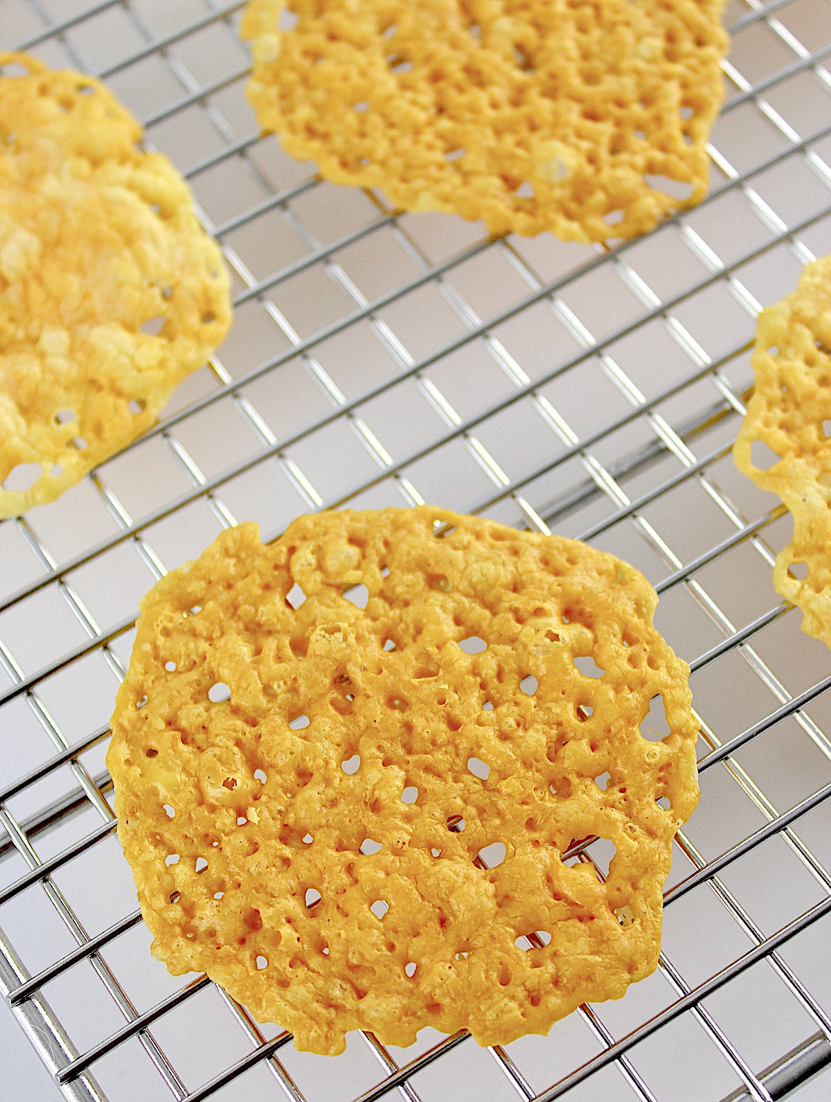 closeup of Keto Baked Cheese Crisp Crackers on cooling rack