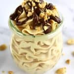 Peanut Butter Mousse in glass open jar with chocolate sauce and chopped peanuts on top