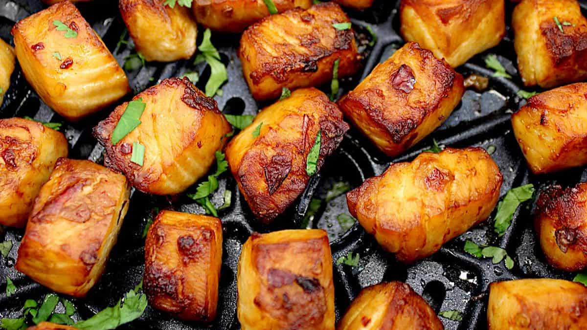 closeup of Air Fryer Salmon Bites in air fryer basket with chopped parsley