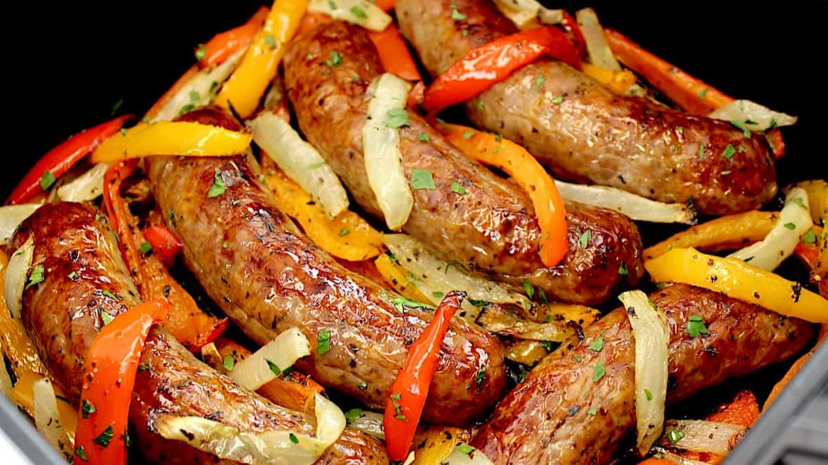 closeup of Air Fryer Sausage, orange and red Peppers, with onions