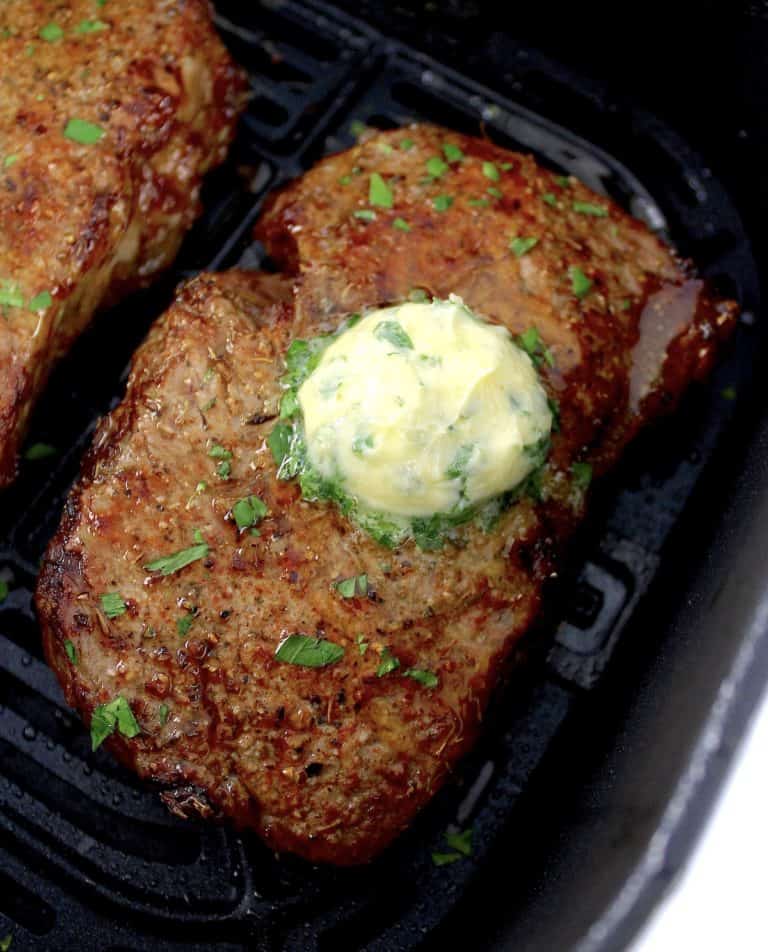 Air Fryer Steak with butter on top in air fryer basket