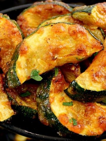closeup of Air Fryer Zucchini in black serving spoon