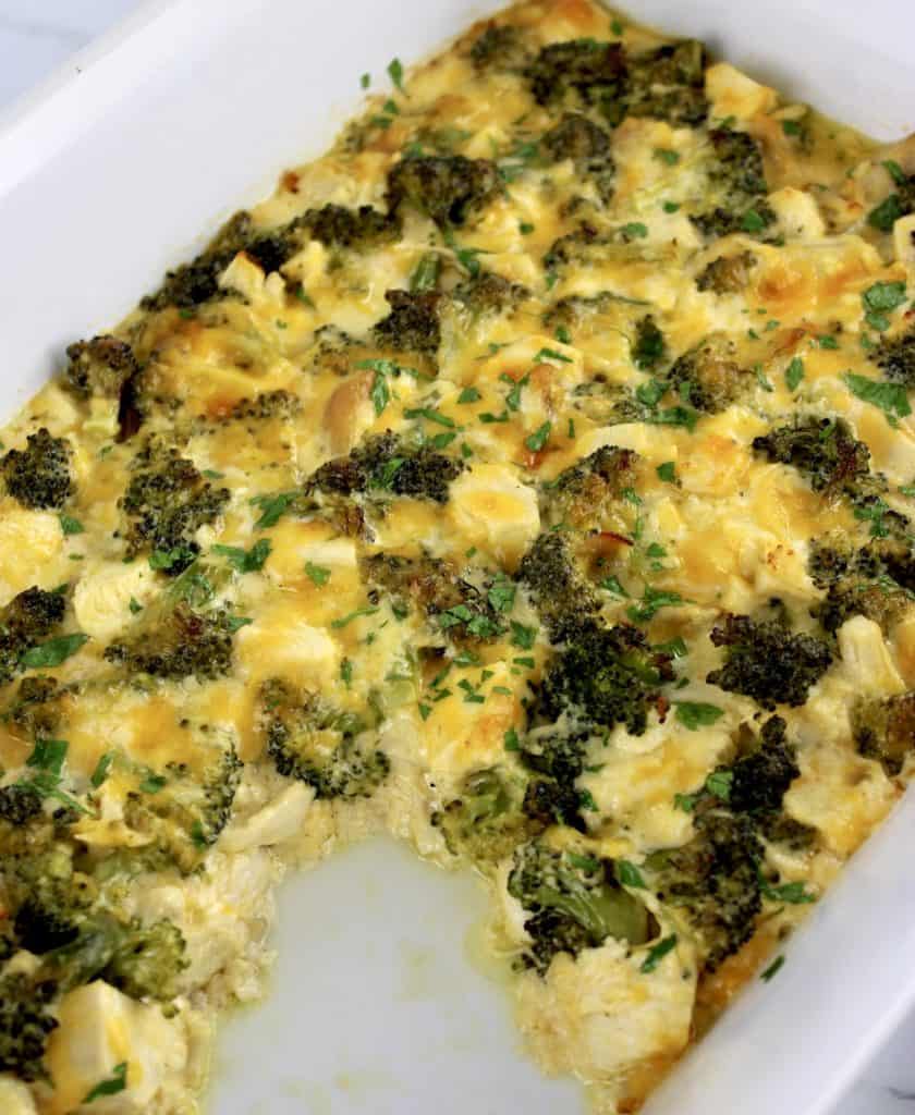 chicken divan casserole in white casserole with piece missing