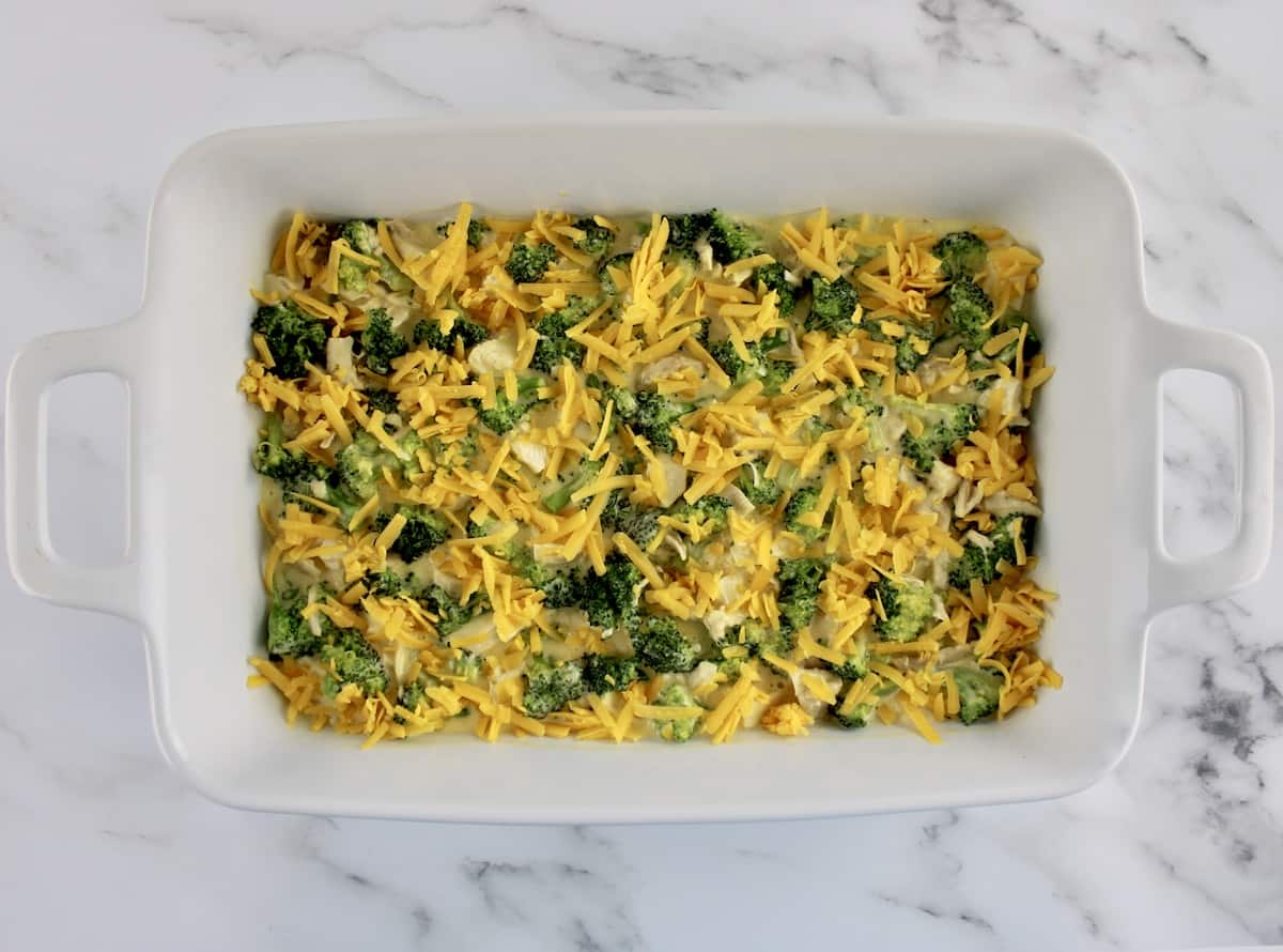 chicken divan casserole with shredded cheddar on top unbaked