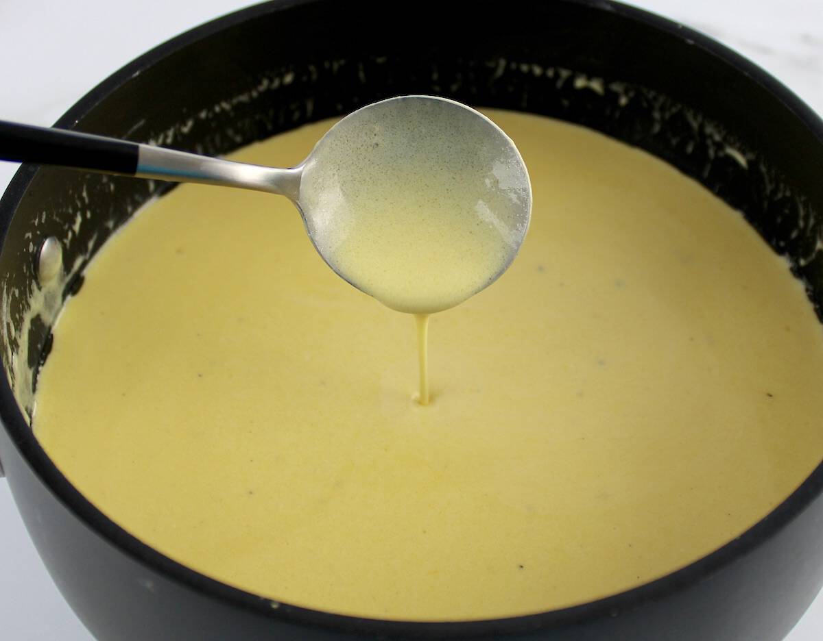 chicken divan casserole cheese sauce in saucepan dripping off spoon