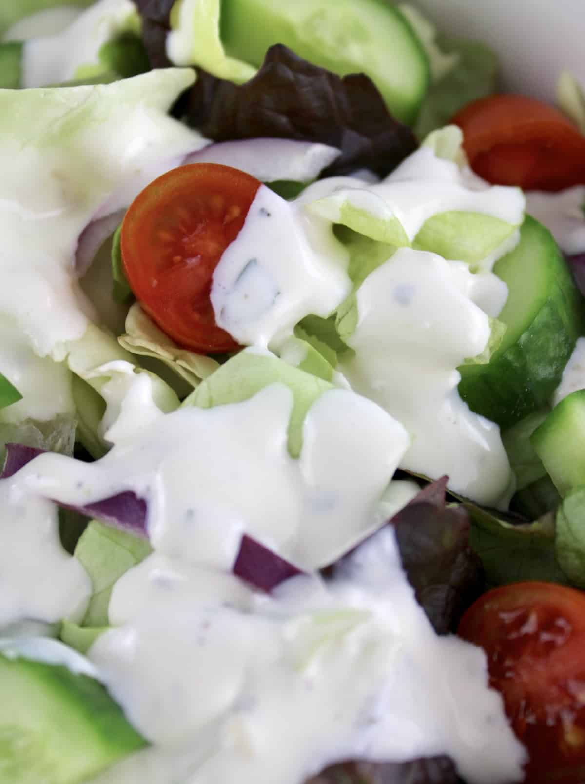 closeup of salad with Creamy Garlic Italian Dressing over top