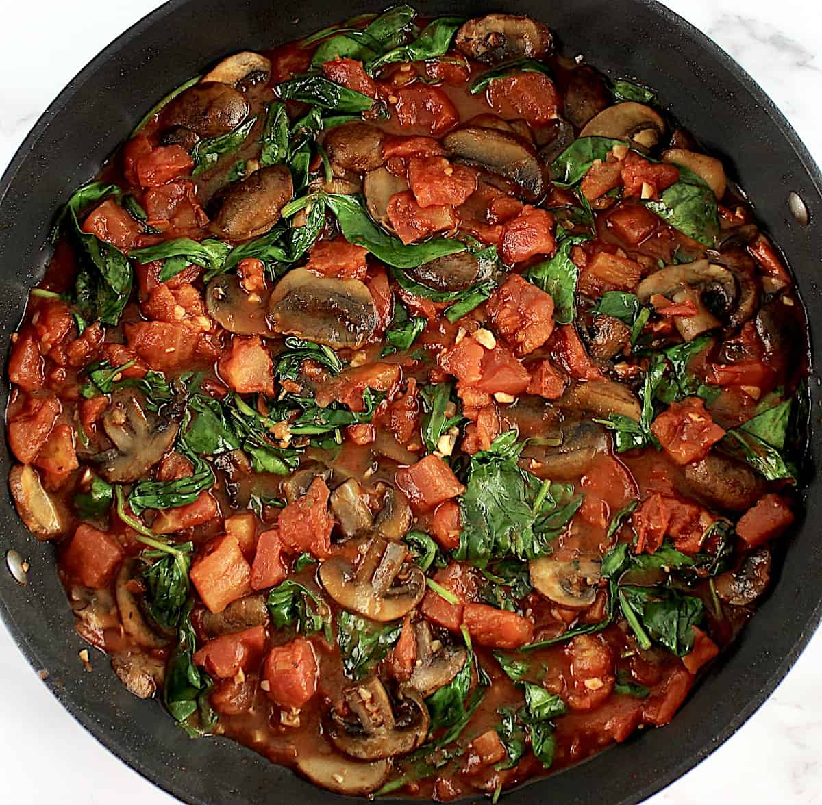 sautéed spinach, mushrooms and tomatoes in skillet