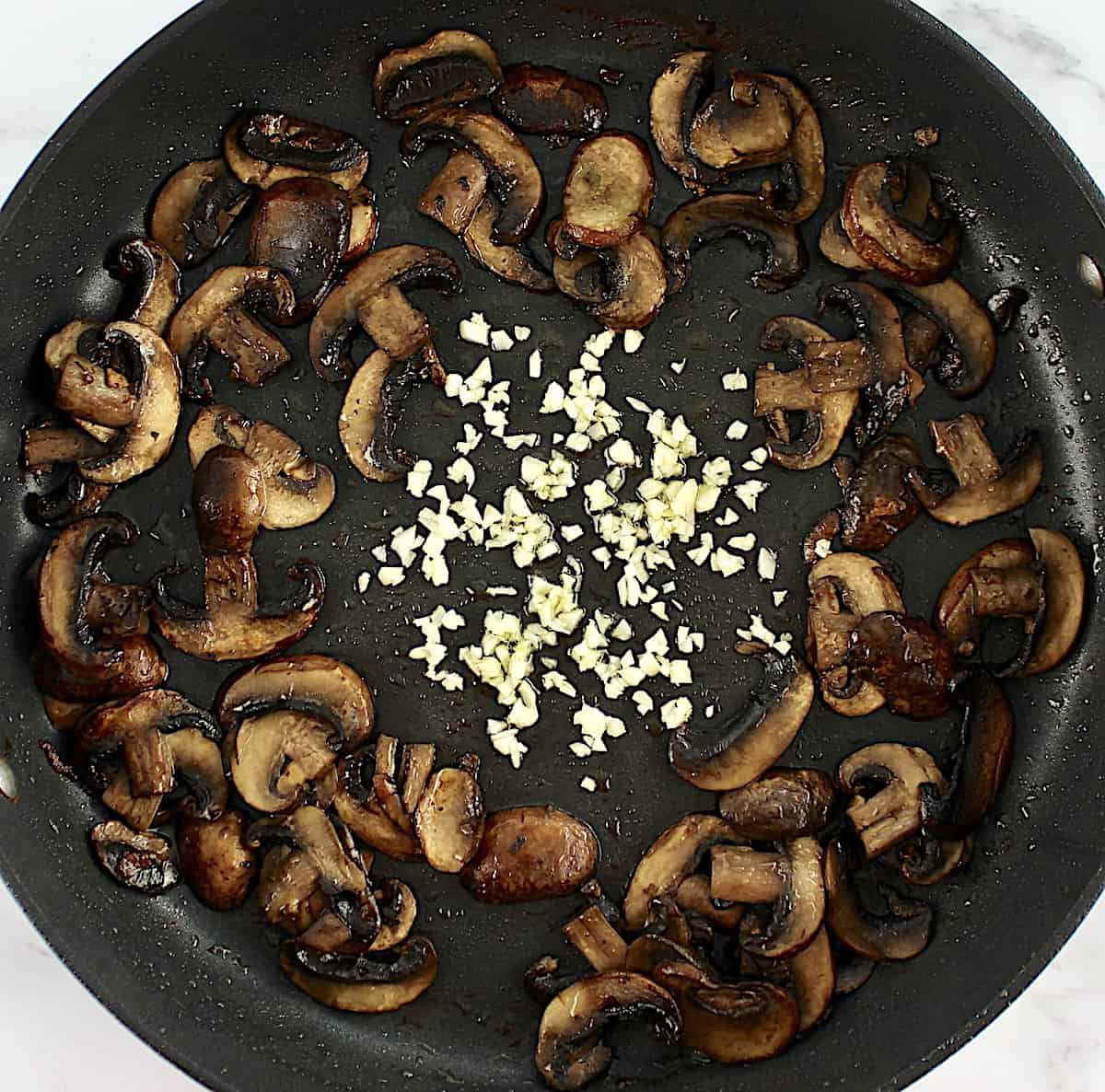 sliced mushrooms and garlic in skillet