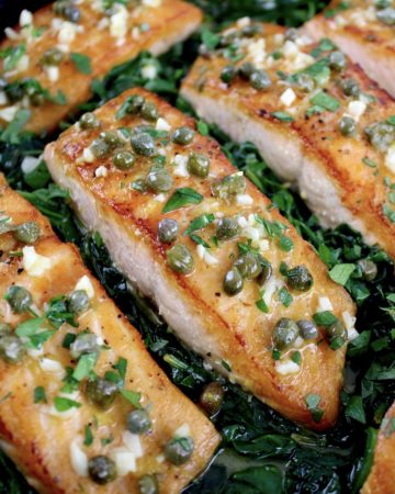 closeup of Salmon Piccata with Spinach with capers on top