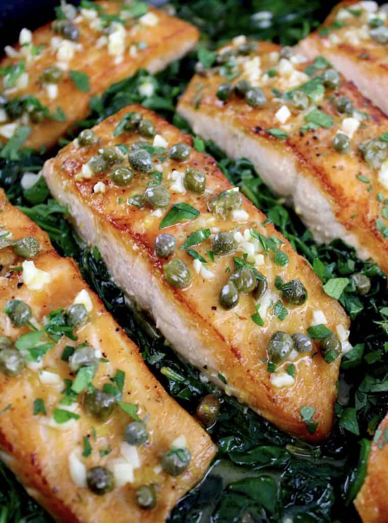 closeup of Salmon Piccata with Spinach with capers on top