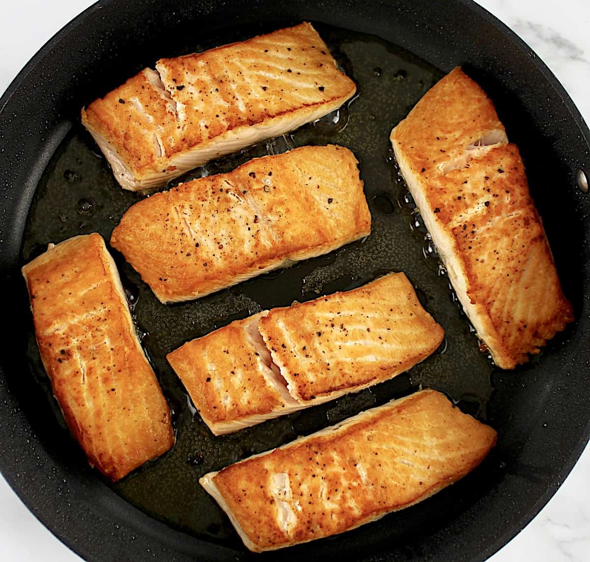 6 pieces of seared salmon in skillet