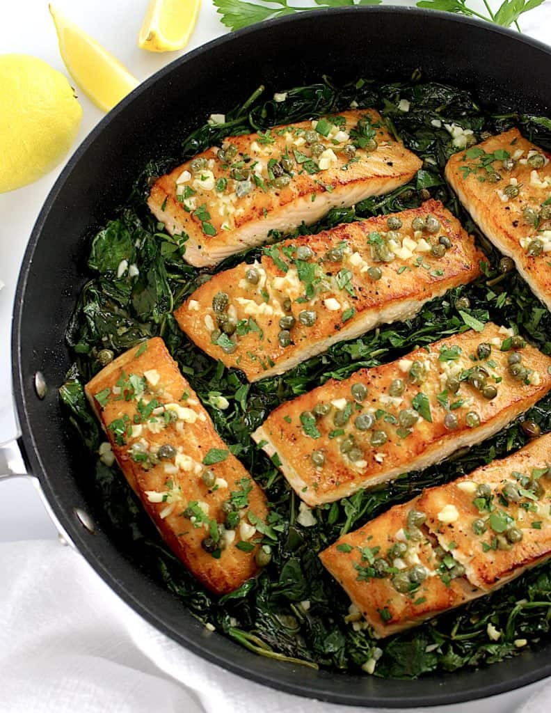 overhead view of Salmon Piccata with Spinach in skillet