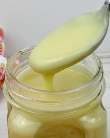 Keto Sweetened Condensed Milk in an open jar some spoonful