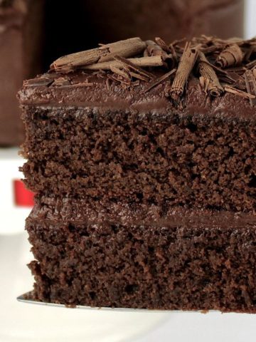 closeup of keto chocolate cake held up with silver cake server