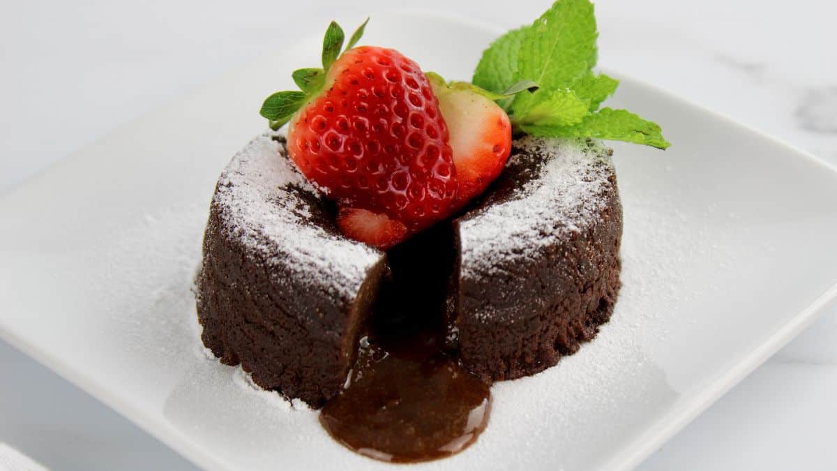 keto nutella lava cake with strawberries on top and chocolate oozing out