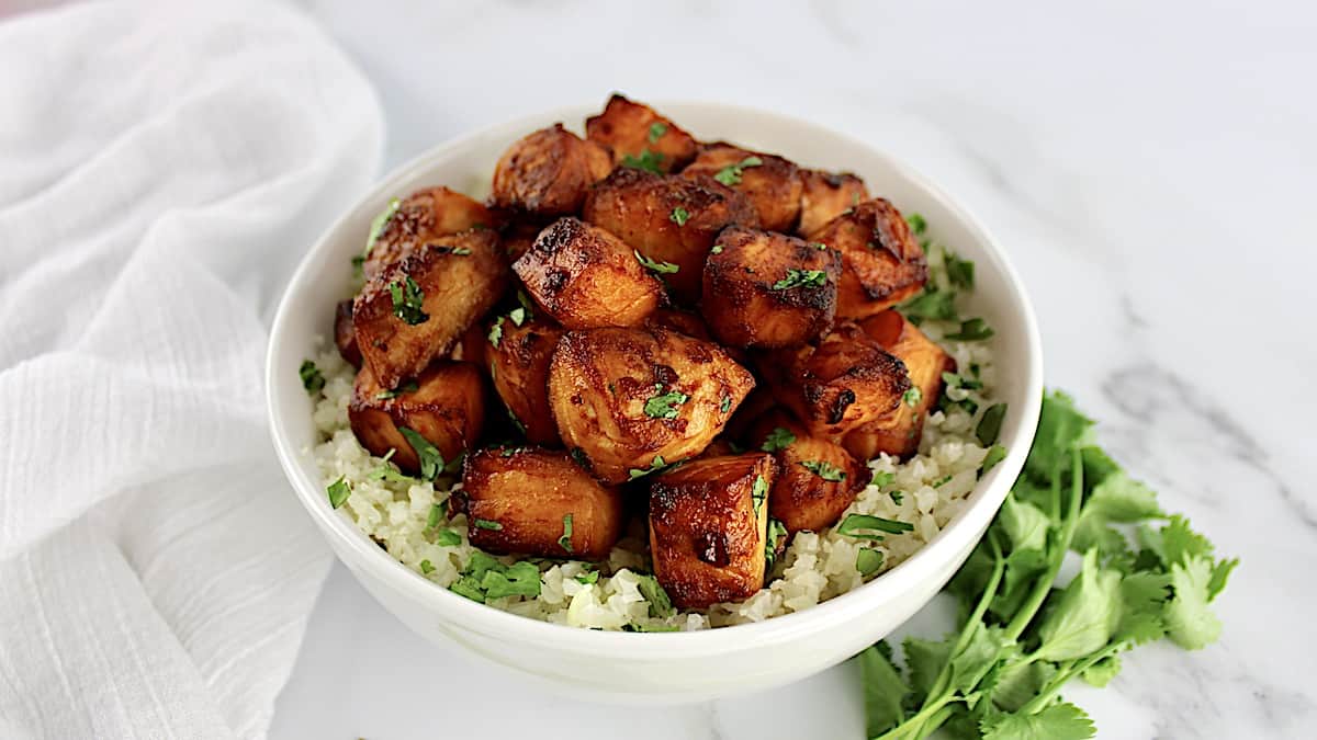 Air Fryer Asian Salmon Bites in white bowl over cauliflower rice