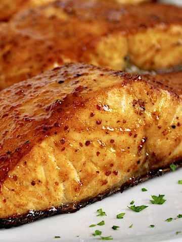 Air Fryer Salmon pieces on white plate with chopped parsley