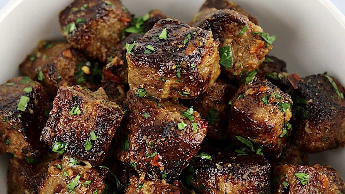 closeup of air fryer steak bites with chopped parsley