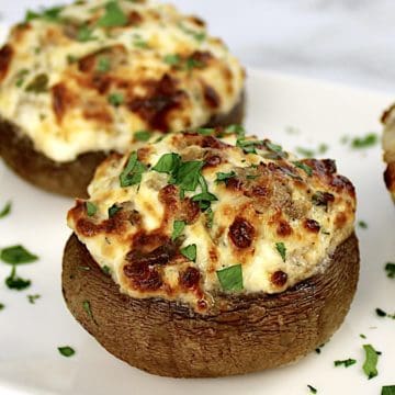 closeup of Air Fryer Stuffed Mushrooms on white plate with chopped parsley