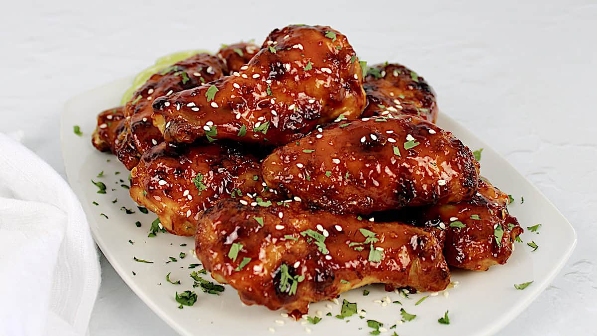 asian sticky wings piled up on white plate