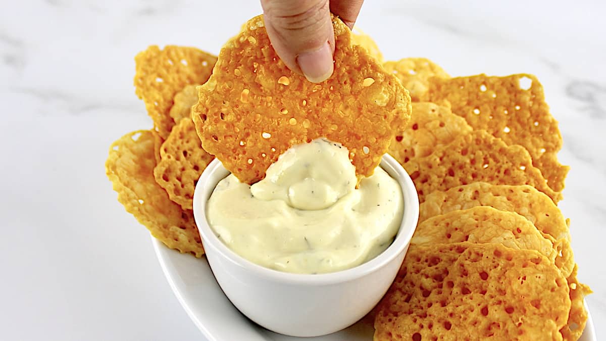 Baked Cheese Crisp Crackers being dipped in ranch dip