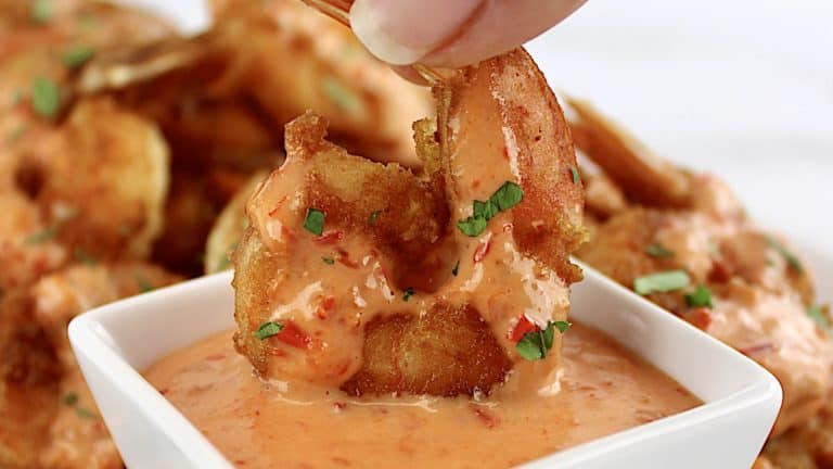 Bang Bang Shrimp being dipped in bang bang sauce