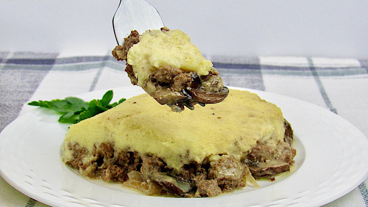 Beef Stroganoff Casserole slice on white plate with piece in fork held up