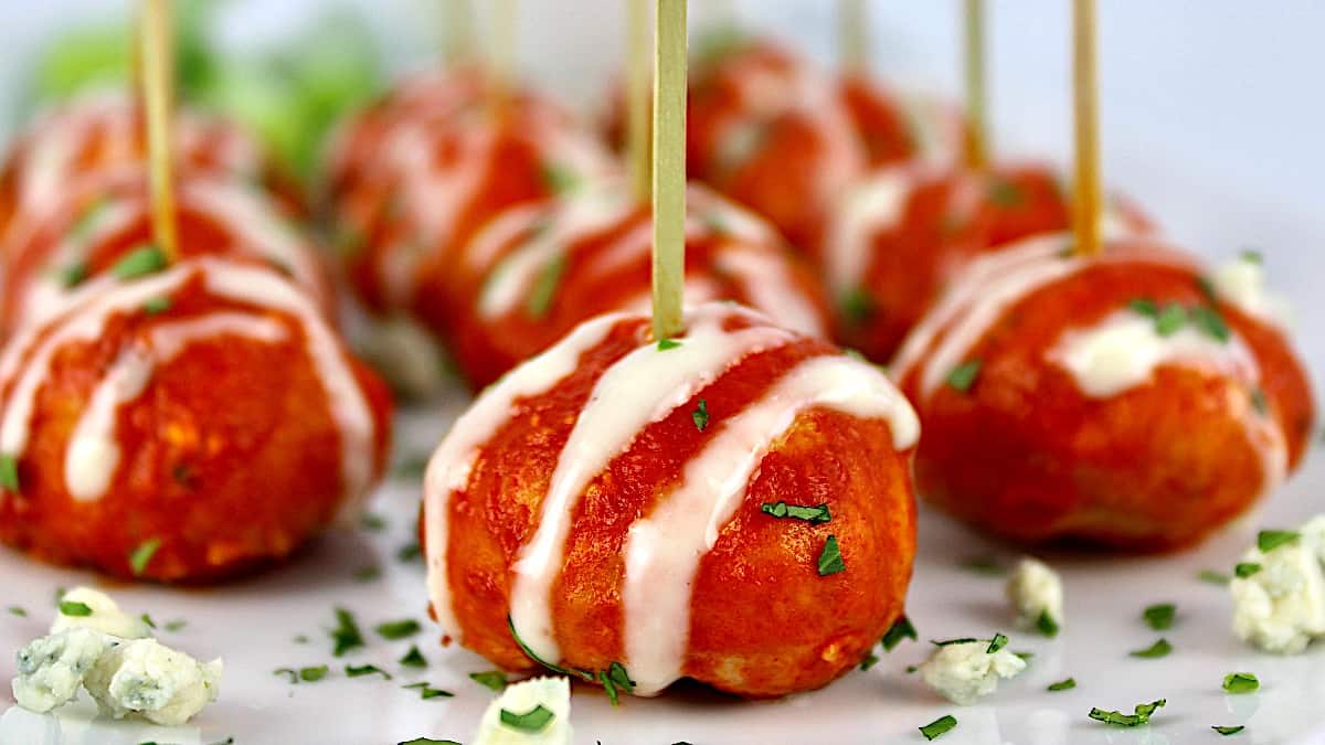 Buffalo Chicken Meatballs with blue cheese drizzled on top and toothpicks in them