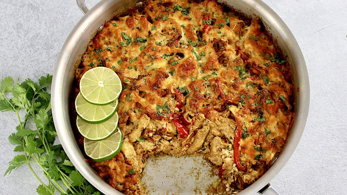 overhead view of Chicken Fajita Casserole in skillet with lime slices