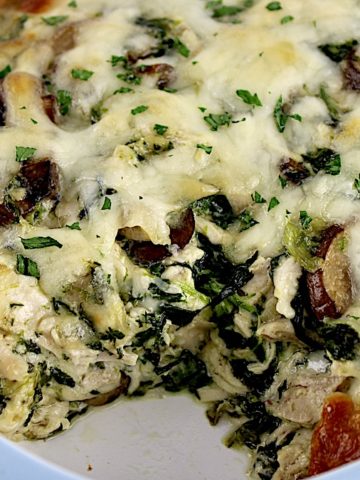 Chicken Florentine Casserole with melted cheese on top and piece missing