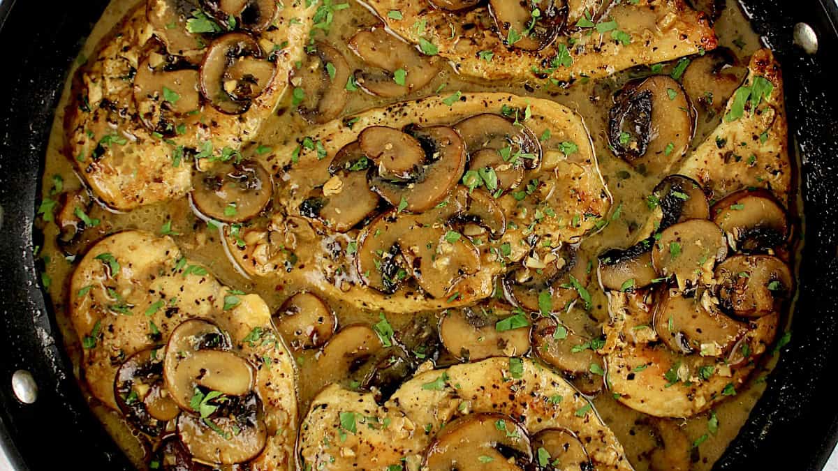 Chicken Marsala in skillet with chopped parsley on top