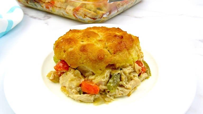 Chicken Pot Pie Casserole piece on white plate with casserole in background