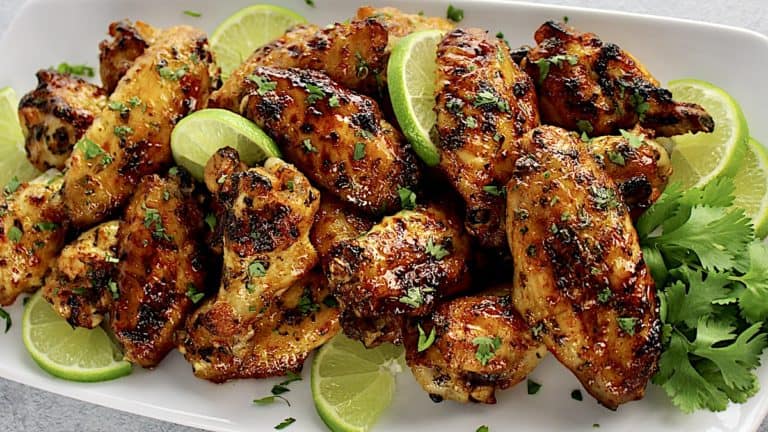 Cilantro Lime Chicken Wings on white oval platter with slices of lime