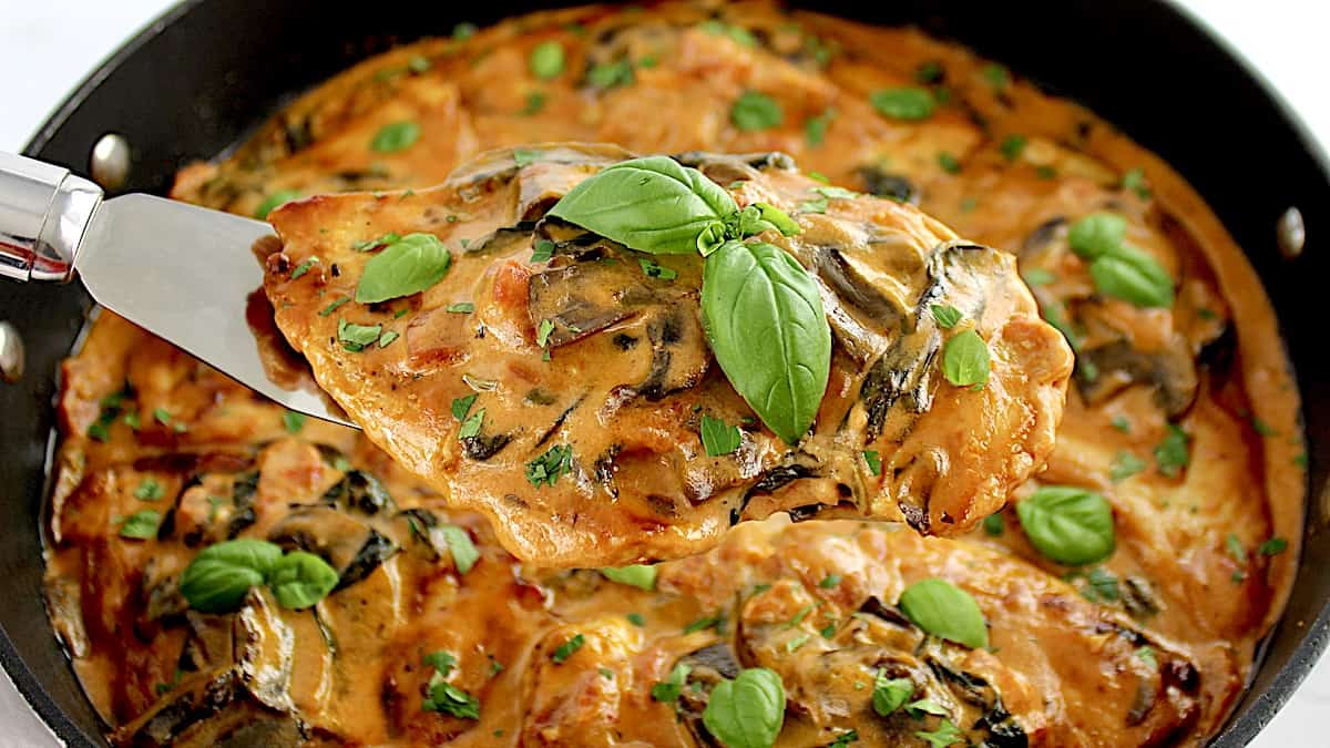 Creamy Tuscan Chicken Skillet held up with spatula