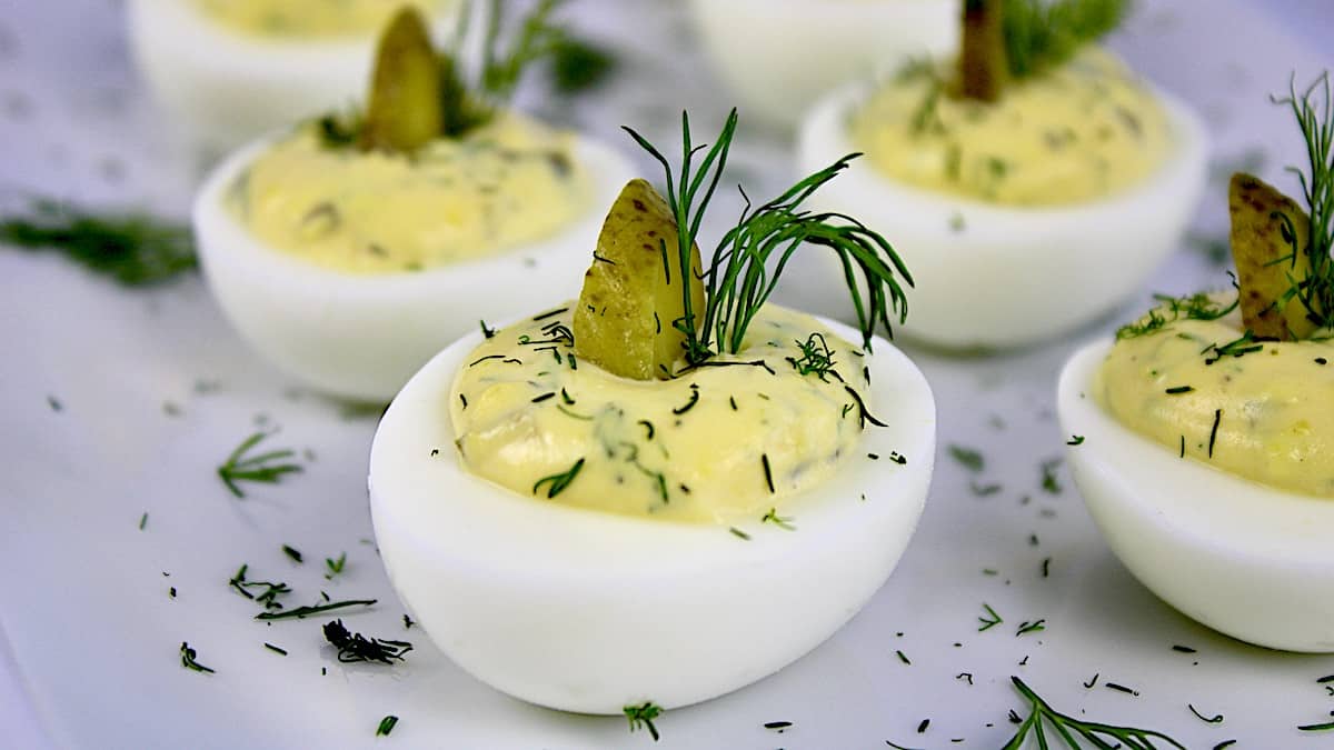 closeup of Dill Pickled Deviled Eggs with pickle slice and dill sprig on top