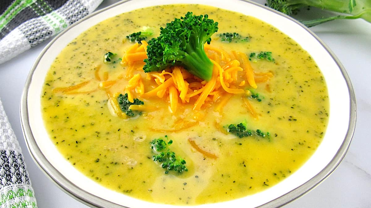 closeup of Keto Broccoli Cheddar Soup with floret and shredded cheddar on top