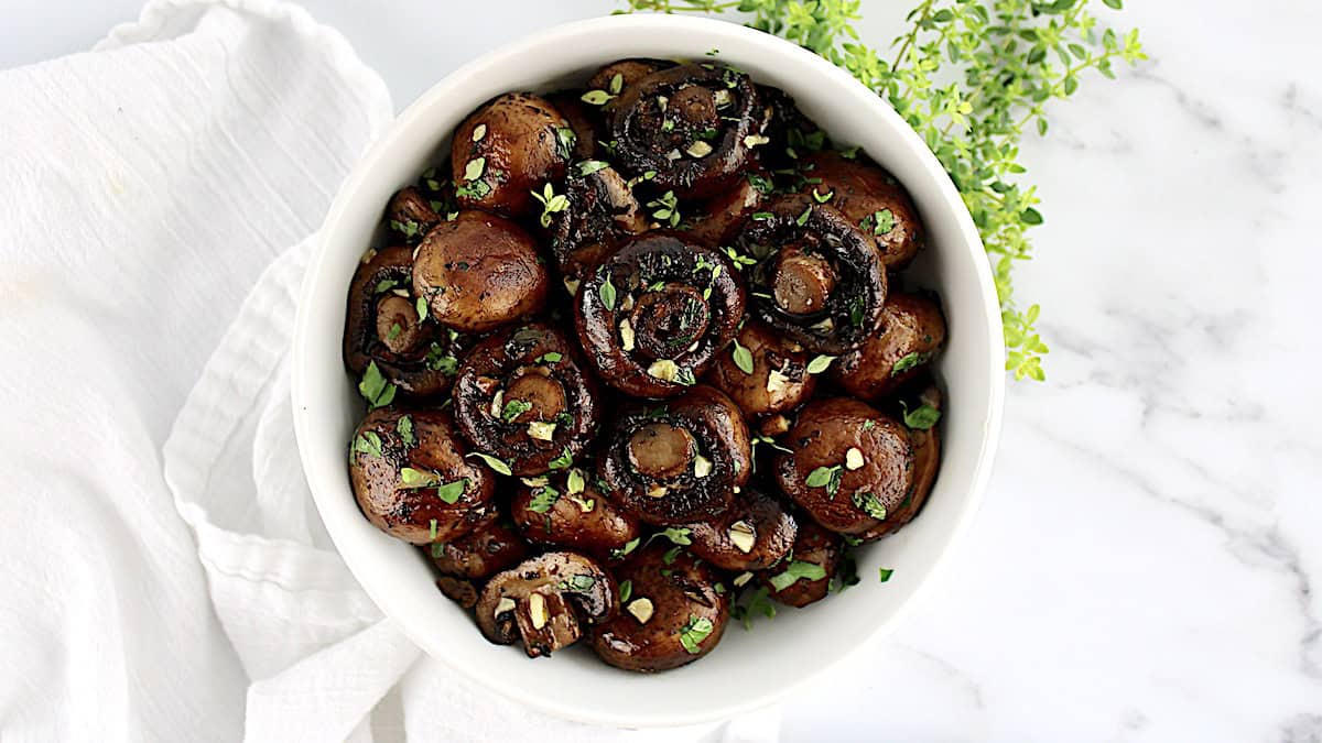 easy sauteed mushrooms in white bowl with fresh parsley