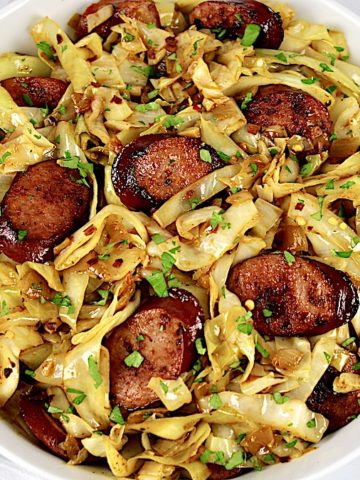 closeup of Fried Cabbage and Sausage in white bowl