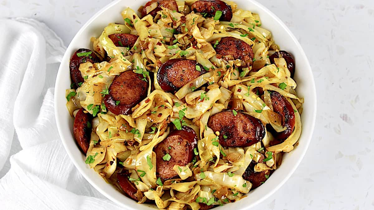 closeup of Fried Cabbage and Sausage in white bowl