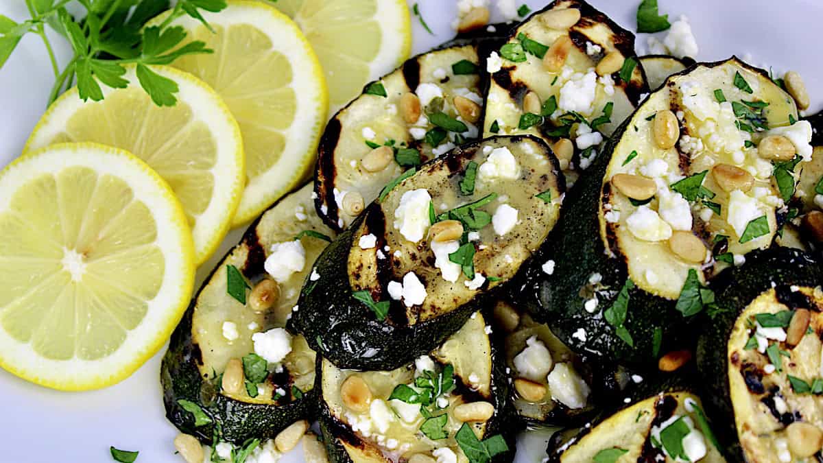 Grilled Zucchini with Feta and lemon slices on white plate