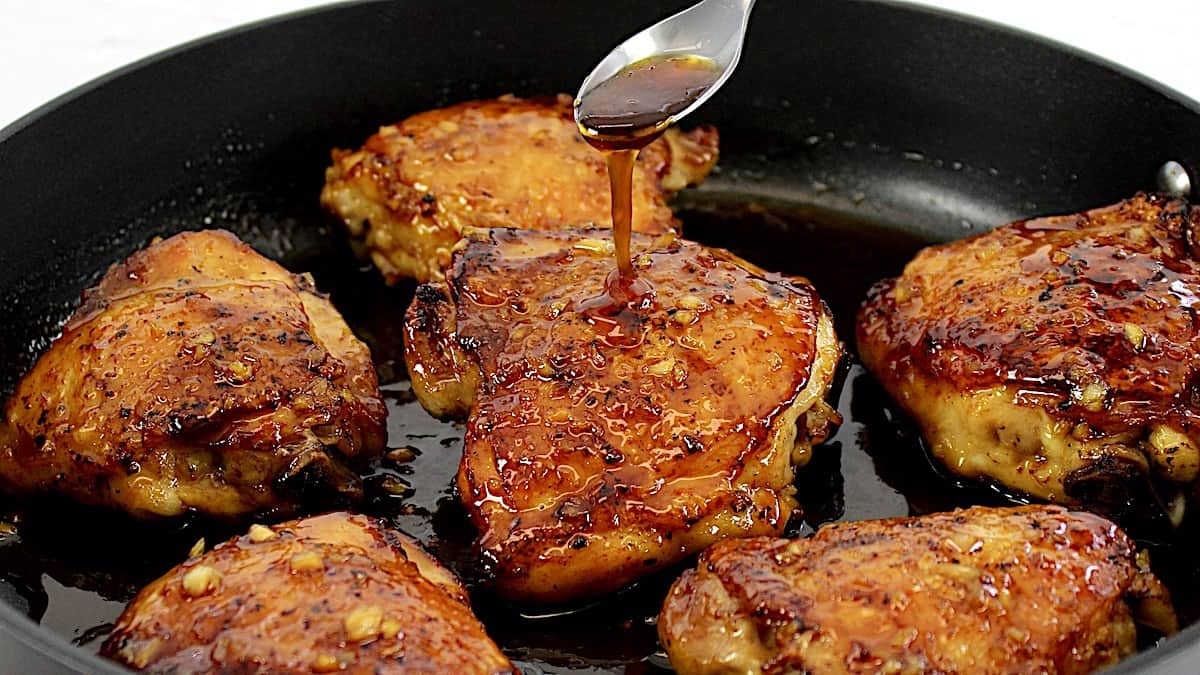 Honey Garlic Chicken in skillet with sauce being poured over top