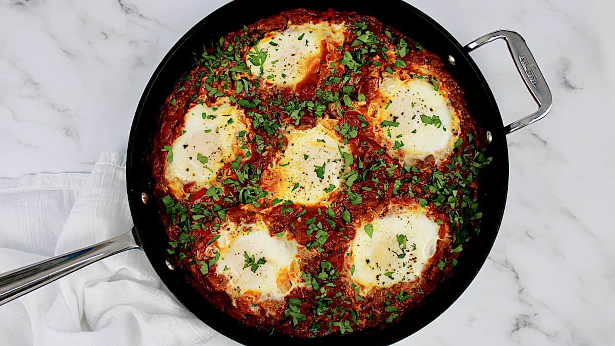 Italian Shakshuka in skillet with chopped parsley over top