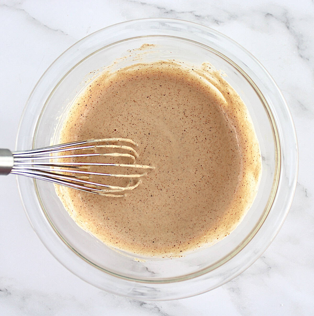 zesty dipping sauce in glass bowl with whisk