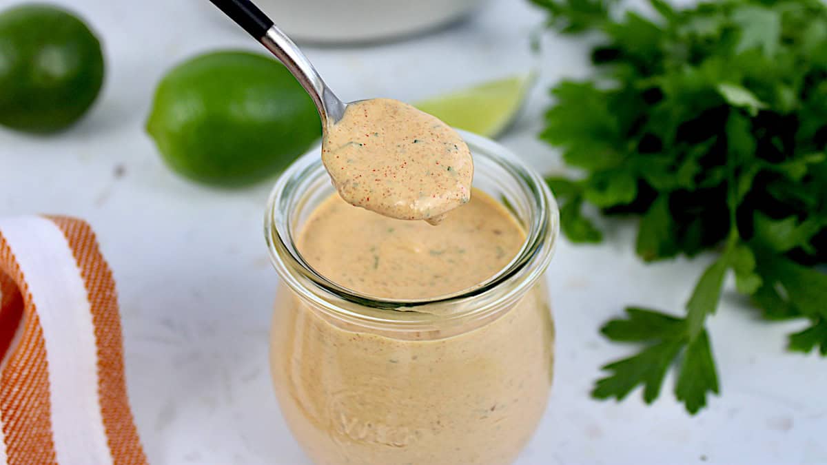 closeup of Keto Chipotle Ranch Dressing in glass jar on spoon