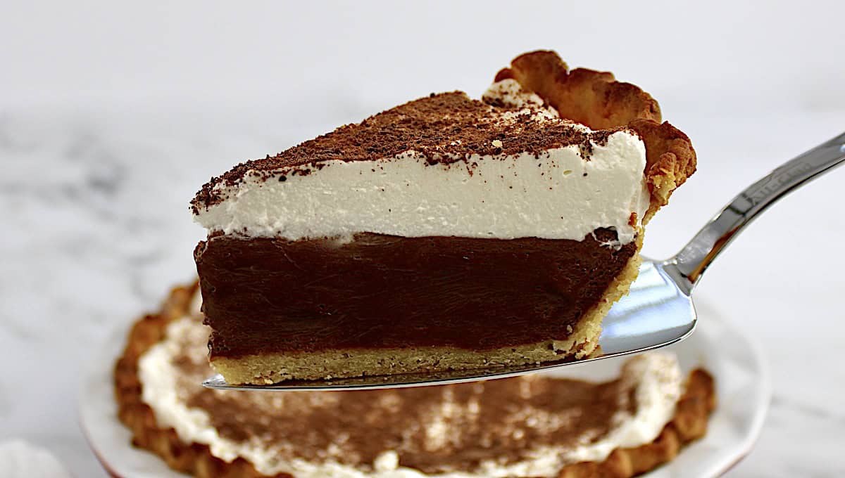 slice of Keto Chocolate Cream Pie on pie server with pie in background